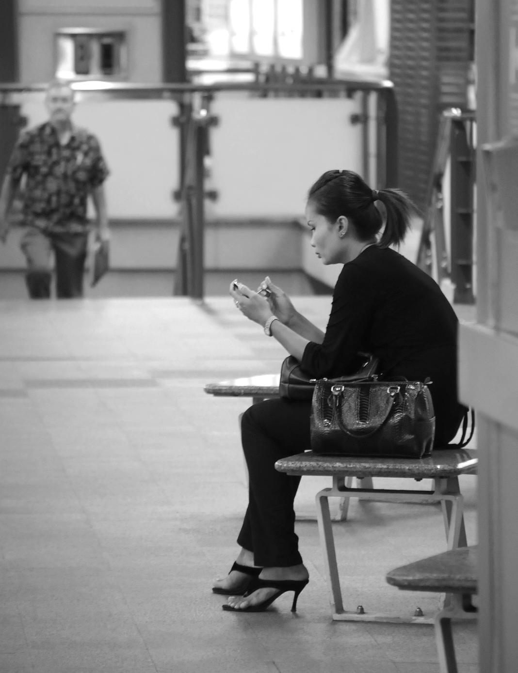 En kvinna i Bangkok sitter på en BTS-station